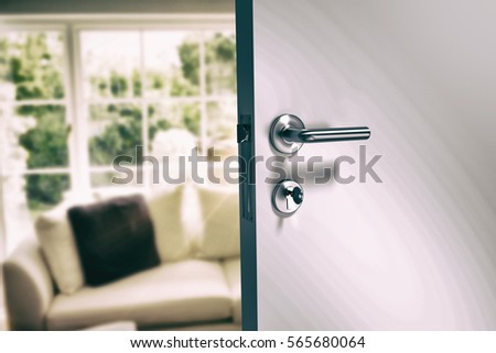 Closeup of metal doorknob and lock with key against sitting room