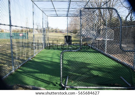 A local high schools batting cage from behind the pitchers safety screen Royalty-Free Stock Photo #565684627