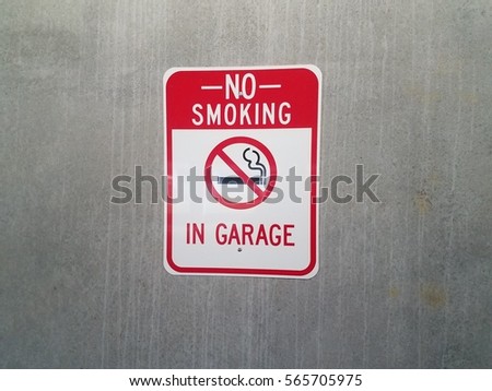 no smoking in the garage sign on cement wall