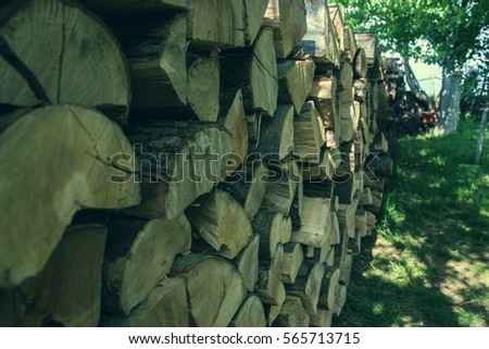 Pile of stacked firewood in rural garden ready for winter. Preparation for the winter. Wooden log abstract background. Dry chopped wood logs