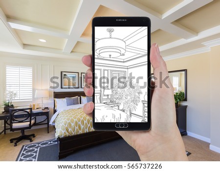 Hand Holding Smart Phone Displaying Drawing of Custom Bedroom Photo Behind.