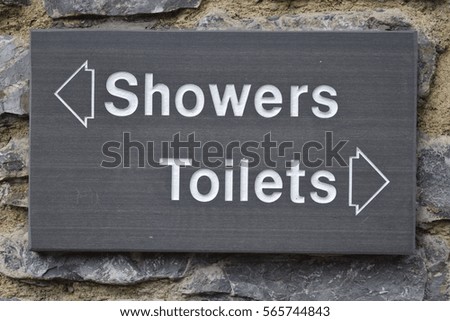 Black signs directing to the toilets and showers