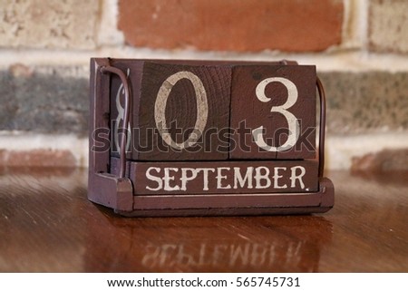 Brown Wooden Calendar Showing the Date of September 3rd with Brick Background