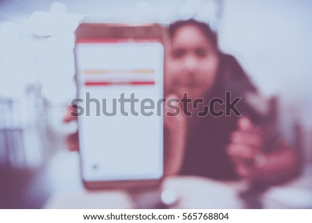 Picture blurred  for background abstract and can be illustration to article of Asian woman showing smartphone
