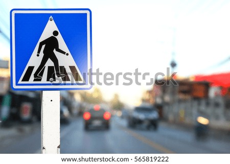 Pedestrian Crossing Sign on blurred traffic background