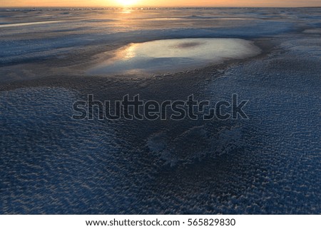 Winter shadows and light of sunset on the ice surface