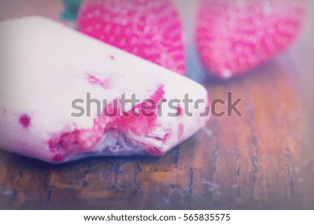 Homemade strawberry ice lolly on a rustic background