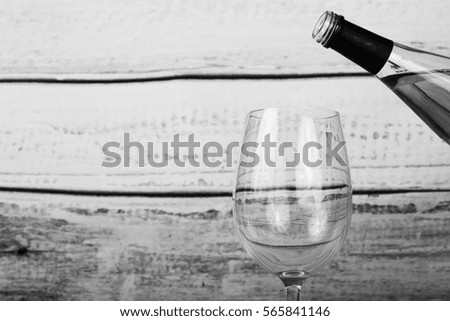 Glass of white wine being poured from a bottle