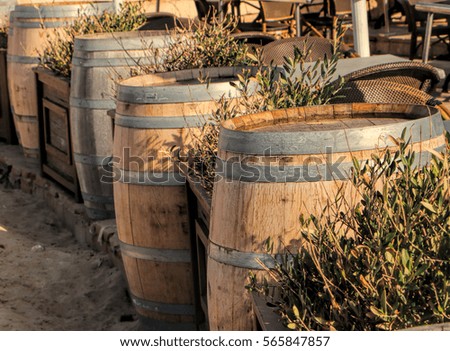Old wooden barrels on a beach in the background a cafe