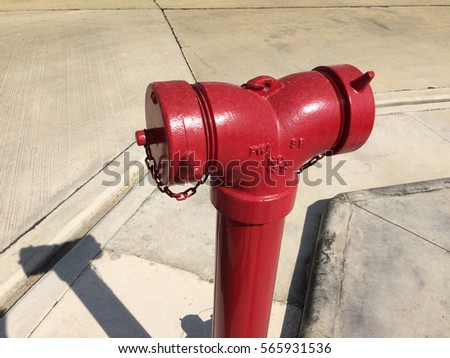 Red metallic fire hydrant or Fire Department Connection on street.