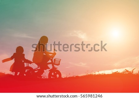 Silhouette of boys and girls are happily rides at the evening sunlight.
