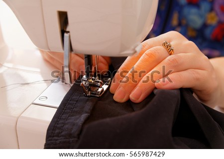 Hands seamstress at the sewing machine 