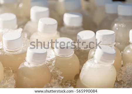 plastic bottles of coconut and palm juice chilled in ice bucket