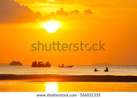 WONDERFUL SUNSET AND BEAUTIFUL SHINING-LIGHT AT SEASIDE IN EVENING , SILHOUETTE BOATS AND FISHERMEN ,GOLDEN SKY CLOUD BACKGROUND