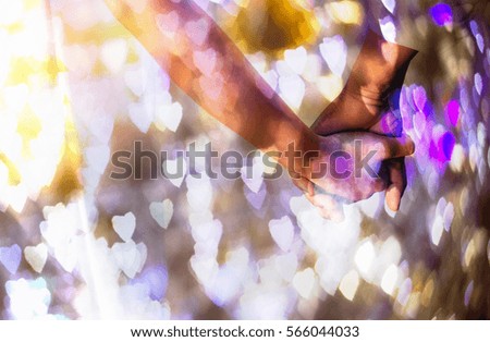 concept love image Hands of man and woman holding together through the bokeh heart shape