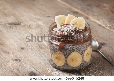 chia pudding with chocolate banana smoothie in a glass jar on the old wooden background Royalty-Free Stock Photo #566045248