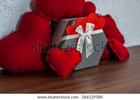Valentine's Day, a packet as a gift for a holiday and a red hearts on the table