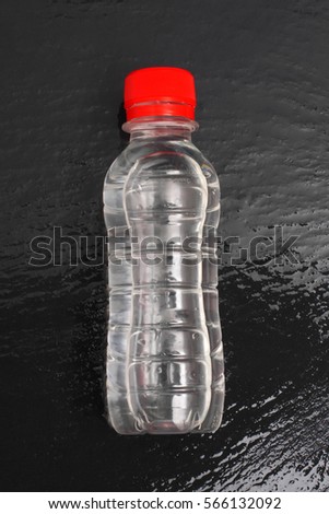  bottle water on wet black bitumen
