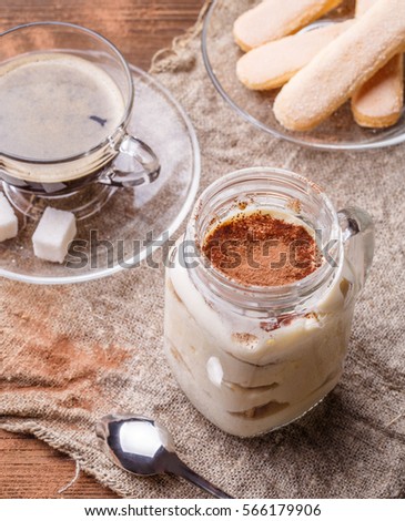 Picture of wooden table with tiramisu, cookies Savoiardi, coffee cup