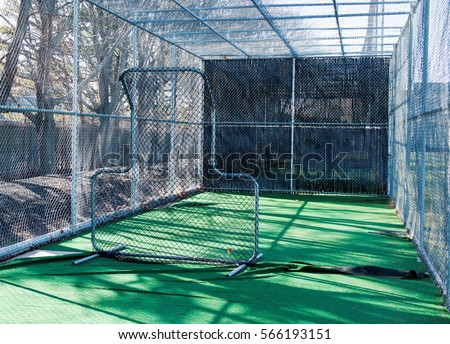 The view from inside a baseball batting cage from behind the pitching screen Royalty-Free Stock Photo #566193151