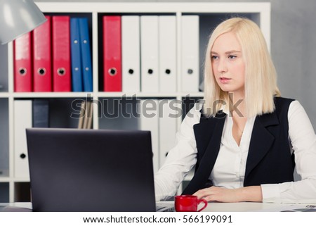 Blonde businesswoman working on laptop