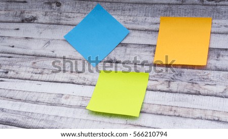 Closeup of Colorful sticky post note with copy space on wooden background. Selective focus.