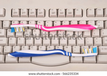One computer keyboard and toothbrushes. Gray color.