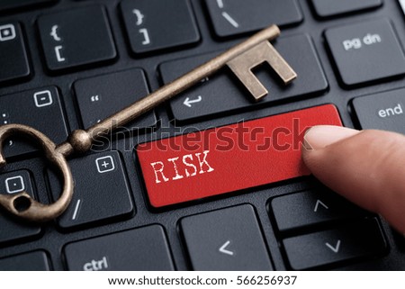 Closed up finger on keyboard with word RISK