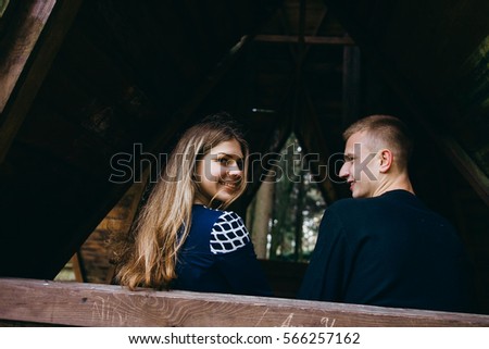 Young couple walking in autumn forest. Gazebo.