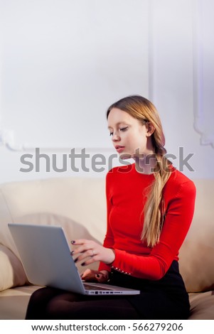 Woman sitting in her living room and using laptop.Watching online stock market.