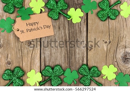 Happy St Patricks Day tag with double border of shiny shamrocks over a rustic wood background