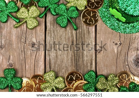 St Patricks Day double border of shamrocks, gold coins and leprechaun hat over rustic wood