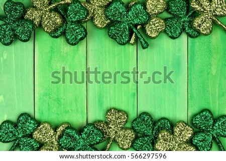 St Patricks Day double border of shiny glitter shamrocks over a green wood background