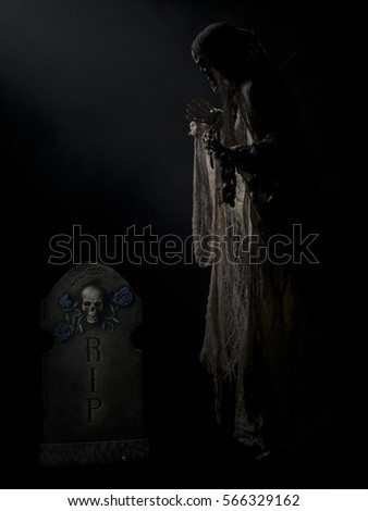 Ghostly figure floating in grave yard on black background halloween themed image