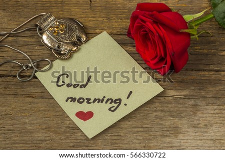 Good morning text on a paper, red rose flower and decoration elephant.