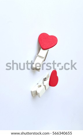 wooden clothes pin or cloth pegs with heart shape design for valentine concept on a white background