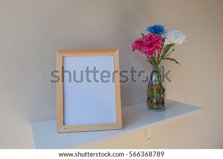 photo Frame on a wooden and Flowers in jar on White background .