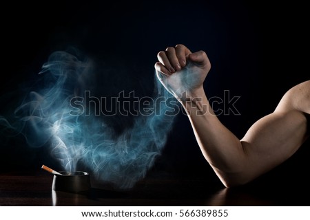 stop smoking concept. Human hand is struggling with a hand of smoke. Quit smoking now