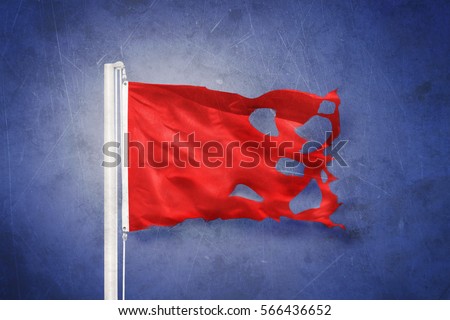 Torn Red flag flying against grunge background.