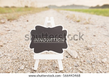 innovation signboard over rocky road with paddy field  background