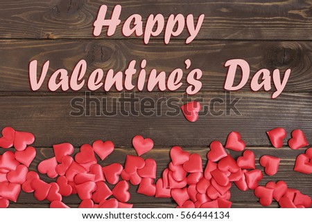 Valentine's day background. Text Happy Valentines day 14 th Feb and a lot of red hearts on wooden background.