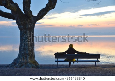 Girl on the bench against lake of Zug, Switzerland