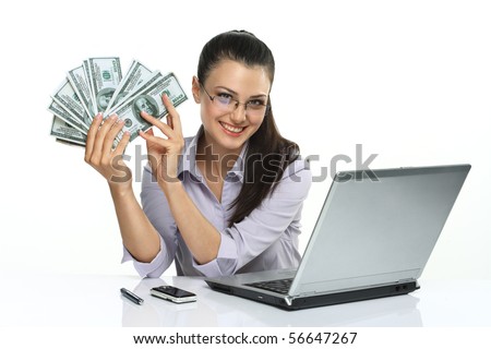 Photo of happy brunette woman in glasses with many dollars near laptop, isolated on white background 