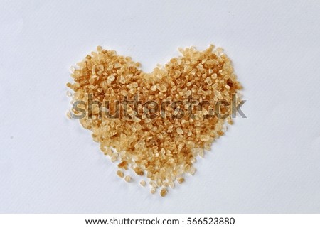 Close up photography of heart shape made from brown sugar grain, isolated on white background.