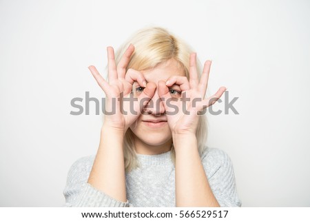 Woman looking through hands, making binoculars