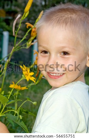 Happy smiling boy with yellow flowers