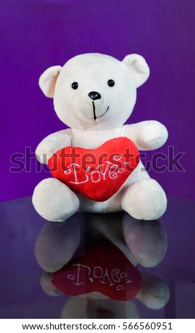 Teddy bear with heart sitting on the glass with  purple background. Get Taste Forever Valentine.