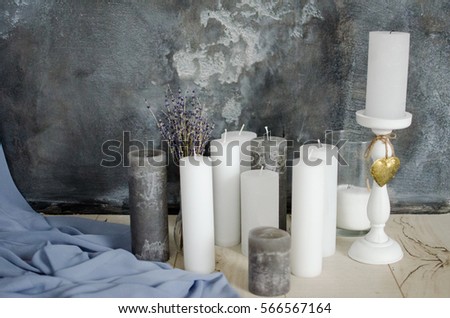 Candles and lavender flowers on a background of gray wall with a blue cloth