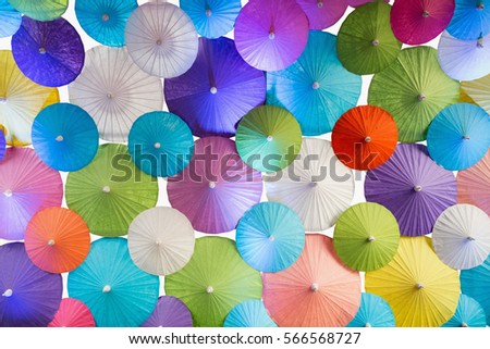 Background / backdrop of colorful handmade paper umbrellas on white background.
