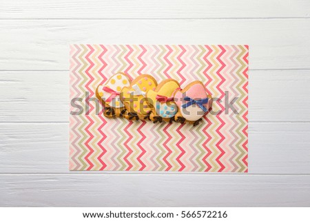 Creative Easter cookies on colourful napkin and white wooden background